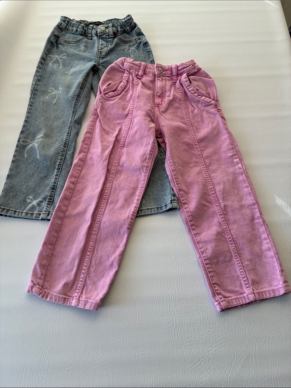 Two pairs of girl jeans. Imperial Star Pink Kids Jeans with Faded Blue Pair